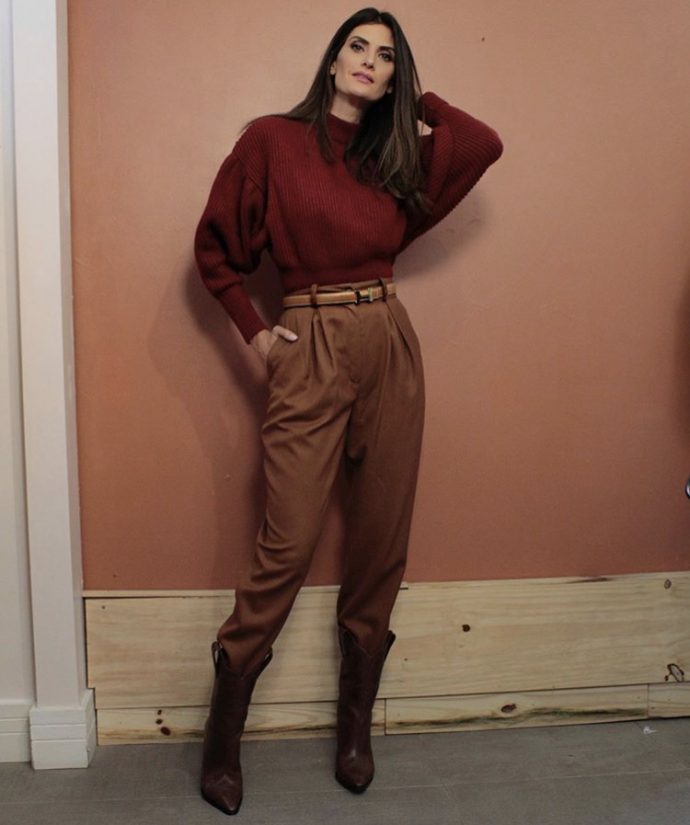 Isabella Fiorentino veste blusa vermelha e calça marrom