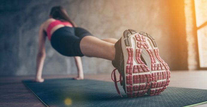 Mulher fazendo prancha num treino de tabata