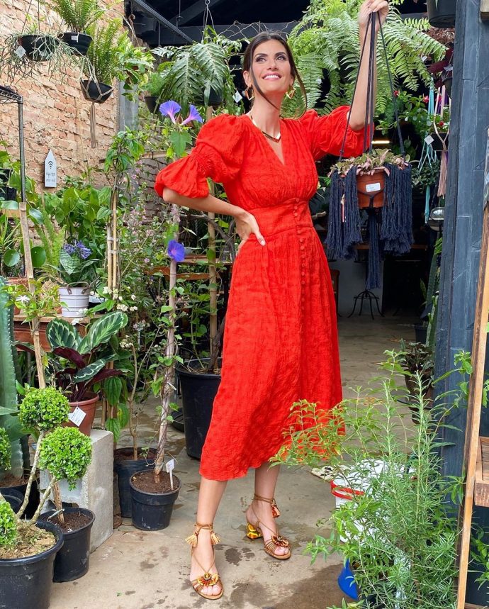 Isabella Fiorentino veste vestido vermelho com tons terrosos nos pés